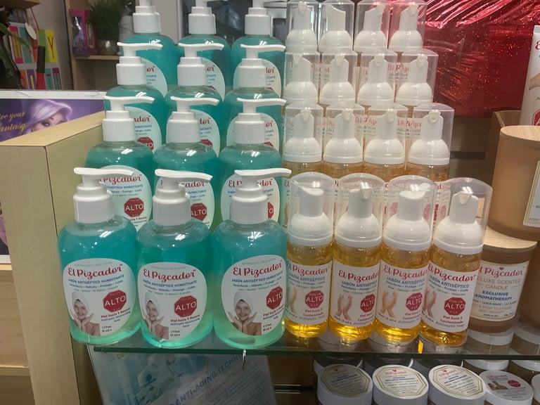 Display of hand sanitizer bottles in various sizes, featuring turquoise and white bottles with red and gold labels on a store shelf